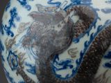 a blue and white vase with a dragon on it