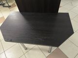 a black table with a black top on a tiled floor