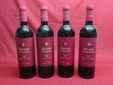 three bottles of red wine are lined up on a pink background