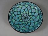 a blue and green plate with a flower design on it