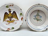 deux assiettes avec un oiseau peint sur une table