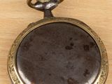 a small pocket watch on a wooden surface