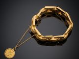 un bracelet en or auquel est suspendue une pièce de monnaie