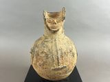 an old vase sitting on top of a black stand