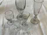 several empty wine glasses sitting on top of a white table cloth