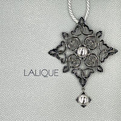 a black and white photo of a cross with a pearl hanging from it