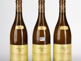 trois bouteilles de vin posées l'une à côté de l'autre sur une table