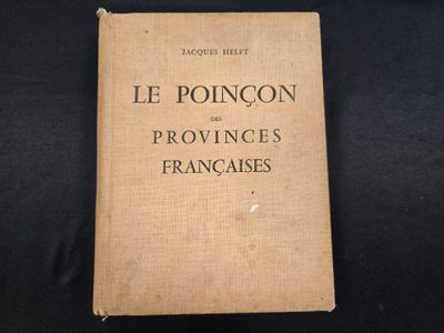 un vieux livre posé sur une table recouverte d'un tissu noir