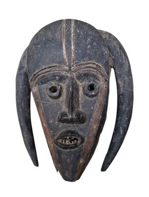 une image représentant un masque en bois muni de cornes sur fond blanc