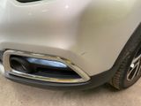 the front end of a silver car with a chrome bumper