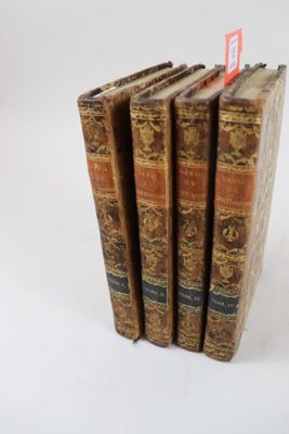 plusieurs vieux livres sont empilés sur une surface blanche