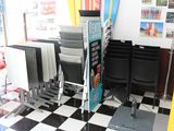 sol à carreaux noirs et blancs dans un salon de coiffure pour hommes, avec des fauteuils et des planches de surf