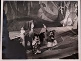black and white photograph of a group of people sitting on a stage