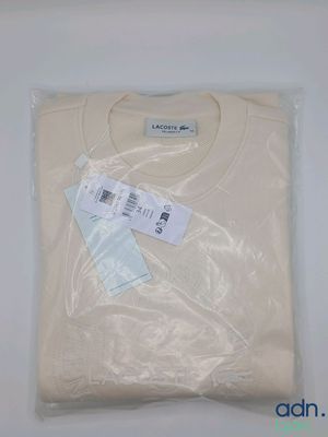 un t-shirt blanc dans un sac en plastique, muni d'une étiquette