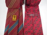 two ties with a gucci logo on them sitting next to each other