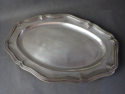 a silver plate on a table with a black background