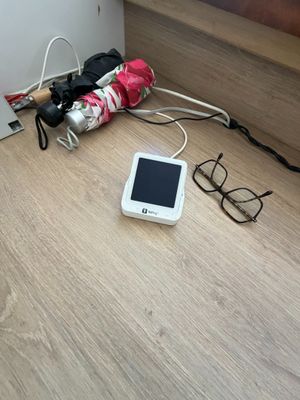un téléphone portable posé par terre à côté d'une paire de lunettes