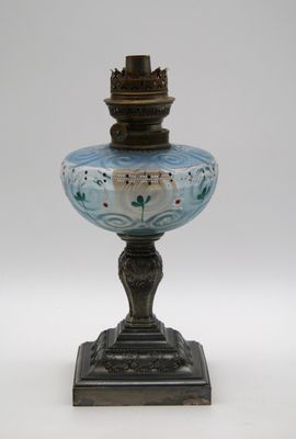 une lampe en verre posée sur un pied