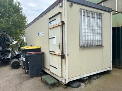 an image of a container house with a trash can in front of it