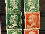 four stamps with different heads on them on a black surface