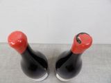 two bottles of wine sitting on a table next to each other