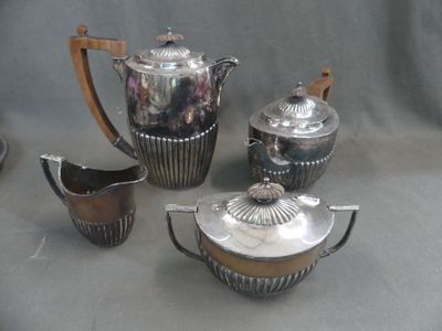 a silver tea set on a table next to other silver items