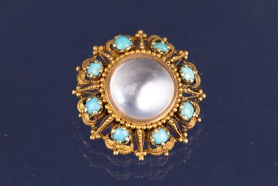 une image représentant une bague en or sertie d'une perle blanche entourée de pierres de turquoise