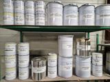 de nombreux pots de peinture posés sur une étagère dans une pièce