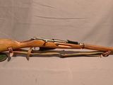 une image d'un fusil en bois avec une poignée verte et un canon en bois