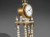 a white and gold clock sitting on top of a table