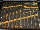 Quelqu'un tient une boîte à outils remplie d'outils dans un garage.