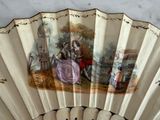 a fan with a painting on it on a table
