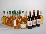 plusieurs bouteilles de vin sont alignées sur une surface blanche