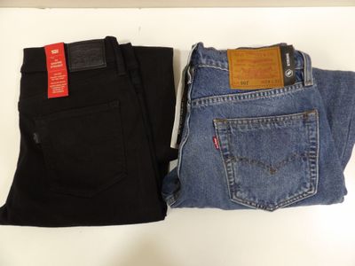 two pairs of levi ' s jeans are sitting on a table