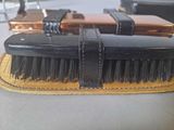 a black brush and a brown case on a table