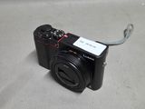 a small black camera with a cord attached to it
