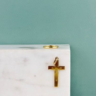 une croix en or posée sur un bloc de marbre blanc, posé sur une table