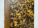 un vieux livre posé sur une table couverte de taches marron et noires