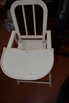 a white chair that is sitting on a brown floor