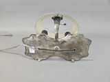 a silver clock that is on top of a piece of metal