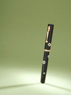 un stylo posé sur une table éclairée par une lampe