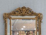 a mirror that is hanging on the wall above a bookshelf