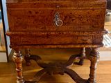 a small wooden chest on a stand on the floor