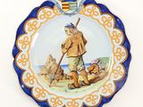a plate with a picture of a man and a dog on it