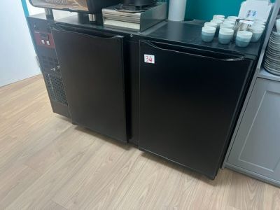 a small black refrigerator in the corner of a kitchen