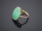 a gold ring with a green jade stone in the center