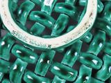 a close up of a green chair with a metal ring