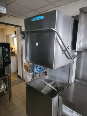 un réfrigérateur en acier inoxydable dans une cuisine équipée d'un évier et d'un lave-vaisselle