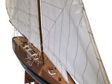 a wooden model of a sailboat with a white sail