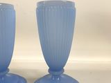 pair of blue glass vases sitting on top of a white counter